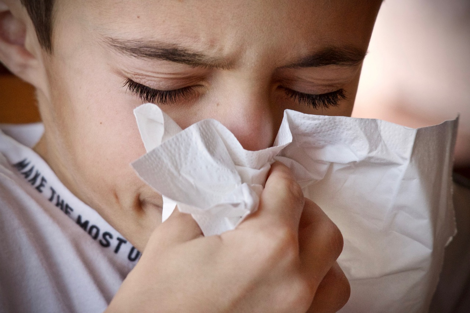 jongetje niest in zakdoek en is allergisch