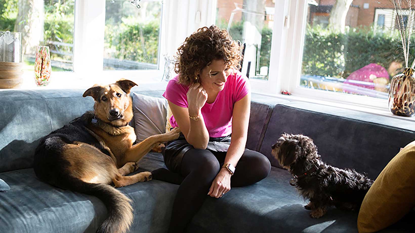 Evelien de Bruijn met haar honden Bruun en Tante Cor thuis op de bank