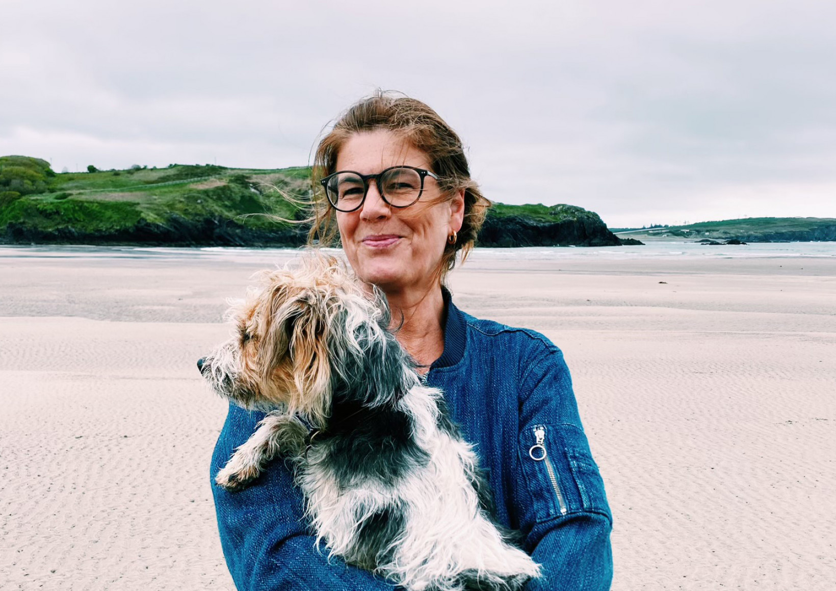 Yvette van Boven met hond Hughie op het strand 