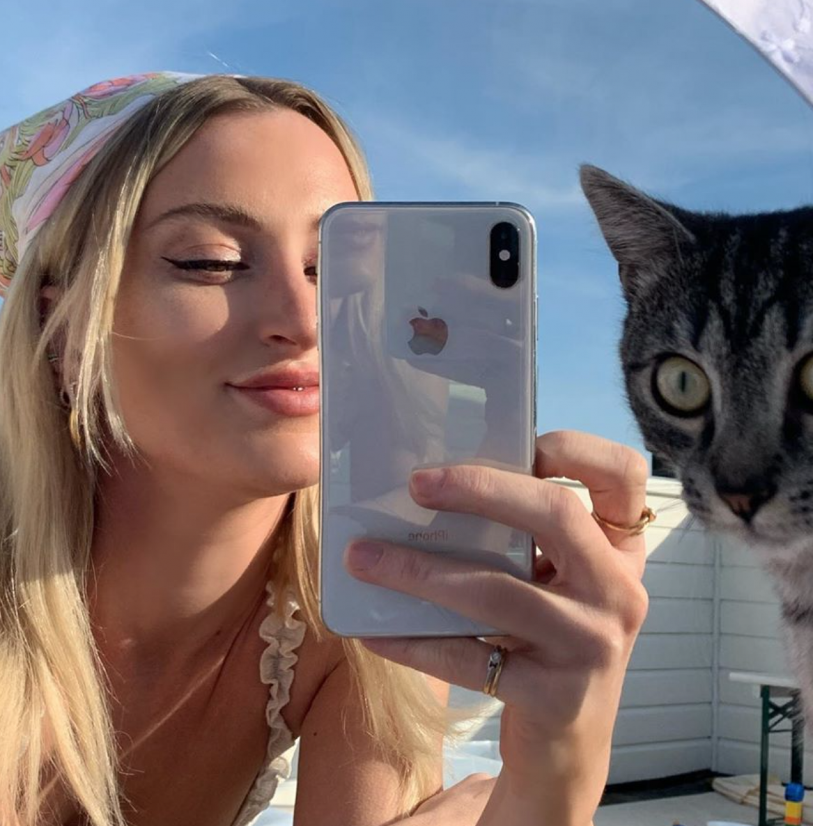 Noor van Queen of Jetlags maakt foto met haar iPhone van haarzelf en haar kat op een dakterras